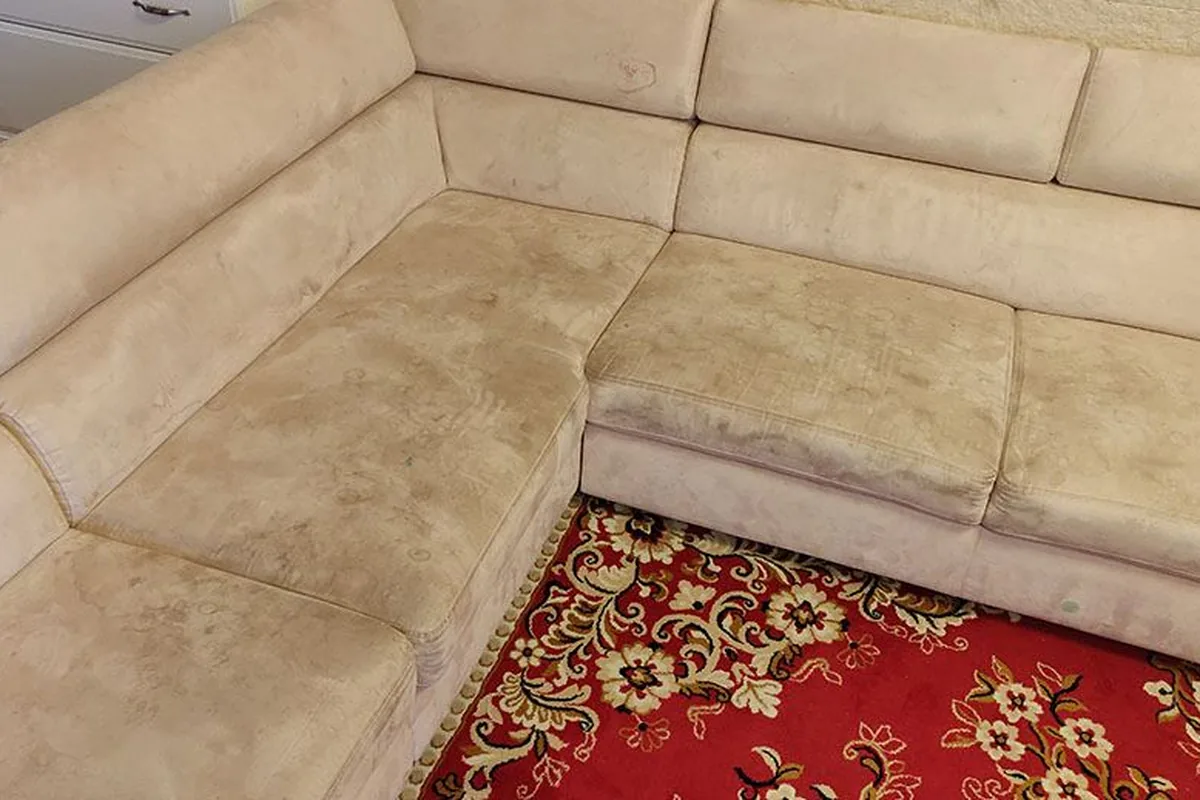Beige corner lounge, ground-in soil across the seats — before cleaning
