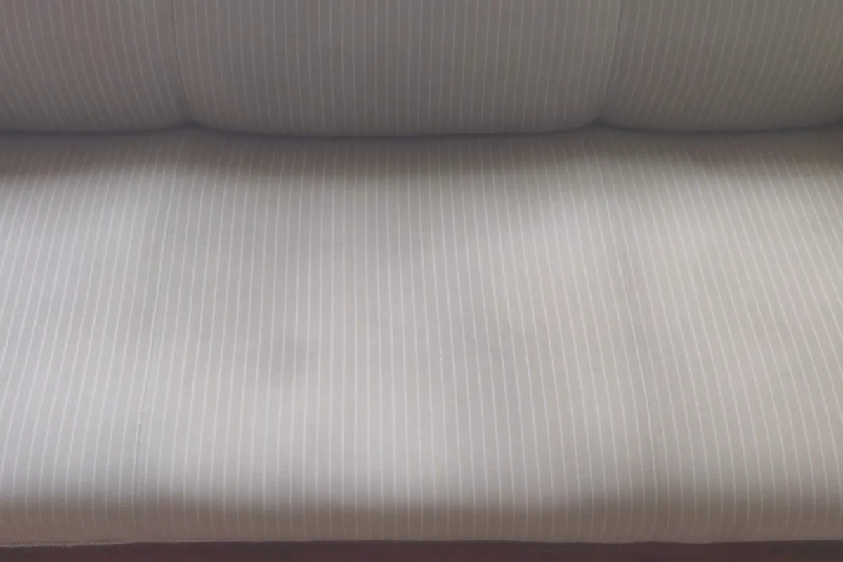 Ribbed white sofa with a stain on the seat — after cleaning by SevenClean